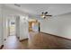 Open room with hardwood flooring flowing into a kitchen area with bright white appliances at 4816 Davisson Ave, Orlando, FL 32804