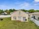 A backyard with a green lawn, grill, and white picket fence offers outdoor living at 5118 Luna Negra Dr, Orlando, FL 32811