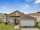 Charming home featuring a two-car garage, neutral paint, and manicured lawn at 5118 Luna Negra Dr, Orlando, FL 32811