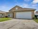 A house featuring a large two-car garage and concrete driveway at 5118 Luna Negra Dr, Orlando, FL 32811