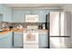 Well-equipped kitchen with blue cabinets, stainless steel refrigerator, and modern appliances at 5118 Luna Negra Dr, Orlando, FL 32811