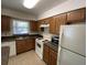 Compact kitchen with wood cabinets, tile floor, and white appliances at 5468 E Michigan E St # 4, Orlando, FL 32812