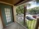 Relaxing patio features a green door and overlooks the parking area with mature trees at 5468 E Michigan E St # 4, Orlando, FL 32812