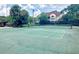 Outdoor tennis court with a view of the building surrounded by mature trees at 5468 E Michigan E St # 4, Orlando, FL 32812