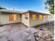 Exterior view of backyard featuring a concrete patio, ample windows, and exterior access door at 553 Floral Dr, Kissimmee, FL 34743