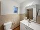Bathroom featuring a white vanity, tile backsplash, and a framed mirror with lighting at 553 Floral Dr, Kissimmee, FL 34743