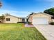 Charming single-story home features a well-manicured lawn, stone accents, and an attached two-car garage at 553 Floral Dr, Kissimmee, FL 34743