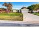 Charming single-story home features a well-manicured lawn, stone accents, and an attached two-car garage at 553 Floral Dr, Kissimmee, FL 34743