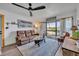 Bright living room showcases a comfortable brown sofa, modern ceiling fan and a scenic lake view through sliding doors at 574 Orange Dr # 78, Altamonte Springs, FL 32701
