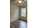 Bedroom featuring a window with blinds, wood-look flooring, and neutral paint at 627 Dory Ln # 202, Altamonte Springs, FL 32714