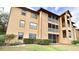 Tan condo building with screened balconies, neat landscaping and a bright, sunny sky at 627 Dory Ln # 202, Altamonte Springs, FL 32714