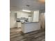 Bright kitchen featuring white cabinets, a breakfast bar, and wood-look vinyl plank flooring at 627 Dory Ln # 202, Altamonte Springs, FL 32714