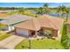 Beautiful aerial view of a brick home with lush landscaping and a tranquil lake nearby at 633 Watercrest Dr, Haines City, FL 33844