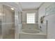 Bright bathroom featuring a glass-enclosed shower and separate soaking tub at 633 Watercrest Dr, Haines City, FL 33844