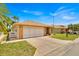 A brick home with a two-car garage, palm tree, and lush lawn at 633 Watercrest Dr, Haines City, FL 33844