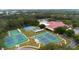 Aerial view of the community, showcasing tennis courts and clubhouse surrounded by lush greenery at 6419 Borg St, Leesburg, FL 34748