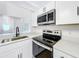 Modern kitchen with stainless steel appliances, quartz countertops, and white cabinetry at 6508 Coral Cove Dr, Orlando, FL 32818