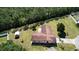 An aerial view of the home, showcasing the lush surroundings and a spacious lawn bordered by tall trees at 717 Wedge Ln, Kissimmee, FL 34759