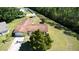 An aerial shot showcases the home's well-manicured lawn, mature trees, and proximity to natural surroundings at 717 Wedge Ln, Kissimmee, FL 34759