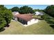 Well-maintained single-story home with a brown roof, green lawn, and mature trees at 717 Wedge Ln, Kissimmee, FL 34759