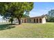 Attractive single-story house on a well maintained lawn with mature trees and covered front porch at 717 Wedge Ln, Kissimmee, FL 34759