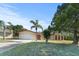 Charming single-story home featuring a manicured lawn, mature trees, and a two-car garage at 717 Wedge Ln, Kissimmee, FL 34759