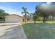 Single-story house with front lawn, mature trees, and a two-car garage in a nice neighborhood at 717 Wedge Ln, Kissimmee, FL 34759