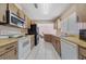 Bright kitchen featuring white appliances, laminate countertops and wood cabinets at 717 Wedge Ln, Kissimmee, FL 34759