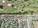 An aerial captures houses near a golf course; lush green fairways bordered by neatly lined homes and streets at 8016 Sweet Orange Ave, Winter Garden, FL 34787