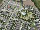 Aerial view of homes with community pool and tennis courts amidst lush greenery and neatly arranged streets at 8016 Sweet Orange Ave, Winter Garden, FL 34787