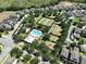 Overhead captures a community pool, tennis courts, playgrounds and homes among lush green trees and manicured lawns at 8016 Sweet Orange Ave, Winter Garden, FL 34787
