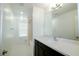 The bright, neutral-toned bathroom features tile flooring, a soaking tub, a large mirror and a single-sink vanity at 8016 Sweet Orange Ave, Winter Garden, FL 34787