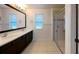 Bathroom featuring dual sinks, large mirror, glass shower, and tile flooring at 8016 Sweet Orange Ave, Winter Garden, FL 34787
