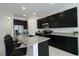 Open-concept kitchen features granite countertops, black cabinets, stainless appliances and an island with seating at 8016 Sweet Orange Ave, Winter Garden, FL 34787