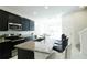 Bright kitchen featuring stainless steel appliances, granite countertops, and modern black cabinetry at 8016 Sweet Orange Ave, Winter Garden, FL 34787