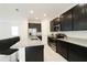 Contemporary kitchen featuring a granite island, black cabinetry, stainless steel appliances, and open layout at 8016 Sweet Orange Ave, Winter Garden, FL 34787
