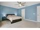 Bedroom with ceiling fan, light-colored wood flooring and blue-painted walls at 8603 Black Creek Blvd, Orlando, FL 32829