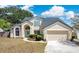 Charming two-story home featuring a two-car garage, a meticulously landscaped front yard, and a walkway leading to the arched entryway at 8603 Black Creek Blvd, Orlando, FL 32829