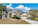Charming two-story home featuring a two-car garage, a meticulously landscaped front yard, and a walkway leading to the arched entryway at 8603 Black Creek Blvd, Orlando, FL 32829