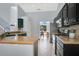 Well-lit kitchen with stainless steel appliances, dark cabinetry, granite countertops, and a view into the dining area at 8603 Black Creek Blvd, Orlando, FL 32829