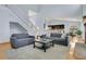 Inviting living room with high ceilings, a staircase, and neutral-toned furniture, flowing into a modern kitchen at 8603 Black Creek Blvd, Orlando, FL 32829