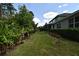 A view of the expansive backyard featuring lush landscaping and a dark metal fence at 8742 Peachtree Park Ct, Windermere, FL 34786