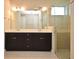 Modern bathroom features a double vanity with a white countertop and dark brown cabinets, plus glass enclosed shower at 8742 Peachtree Park Ct, Windermere, FL 34786