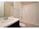 Bright bathroom showcasing a single sink vanity with stone countertop, toilet, and bathtub with white subway tile at 8742 Peachtree Park Ct, Windermere, FL 34786