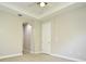 Bedroom with neutral walls and carpet, an arched doorway, and a window at 8742 Peachtree Park Ct, Windermere, FL 34786