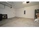 A spacious two-car garage with white walls, cement floors and an overhead garage door system at 8742 Peachtree Park Ct, Windermere, FL 34786