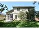 Spacious backyard with lush green grass, screened in porch, and mature trees offering shade at 9573 Southern Garden Cir, Altamonte Springs, FL 32714