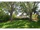Large, grassy backyard with mature trees and a hedge providing privacy, perfect for outdoor enjoyment at 9573 Southern Garden Cir, Altamonte Springs, FL 32714