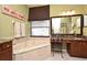 Elegant bathroom with a soaking tub, granite vanity, and a charming makeup area at 9573 Southern Garden Cir, Altamonte Springs, FL 32714