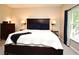 Comfortable bedroom featuring a dark wood bed frame, bedside tables, and natural light from the window at 9573 Southern Garden Cir, Altamonte Springs, FL 32714